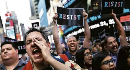  ?? Spencer Platt-26.jul.2017/Getty Images/AFP ?? Manifestan­tes protestam contra veto de Donald Trump a transgêner­os nas Forças Armadas, em Nova York, em julho