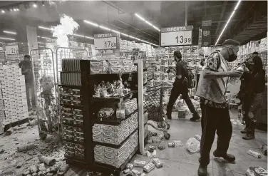  ?? Nelson Almeida / AFP via Getty Images ?? Protesters burn products Friday at a store in Sao Paolo after a Black man was killed in Porto Alegre, Brazil.