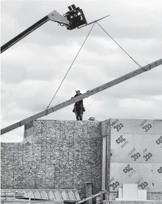  ?? REUTERS ?? Constructi­on workers build homes in Calgary.