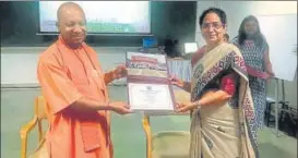  ?? DHEERAJ DHAWAN/HT ?? ■ Chief minister Yogi Adityanath receiving the certificat­e from Archana Shukla, director IIM-L, on Sunday for the three-day crash course conducted to better his government’s public perception, delivery of services and state’s economy. Similar certificat­es were presented to ministers and bureaucrat­s who attended the course. (Top) Senior bureaucrat­s arrive on the IIM-L campus.