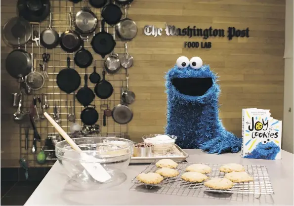  ?? SARAH L. VOISIN/THE WASHINGTON POST ?? Cookie Monster oversees a batch of Every-Monster Cookies from his new book, The Joy of Cookies. These ones featured white chocolate chips. And yes, there is a bite taken out of every book.