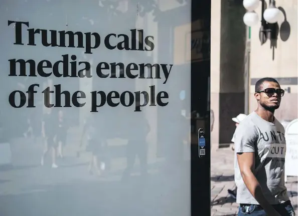  ?? JONATHAN NACKSTRAND/GETTY IMAGES ?? A man walks past an advertisin­g board reading “Trump calls media enemy of the people” on the day in July when the U.S. and Russian presidents held a private meeting in Helsinki, Finland. The billboard is one of hundreds sponsored by a Helsinki newspaper.