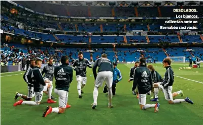  ??  ?? DESOLADOS.Los blancos calientan ante un Bernabéu casi vacío.