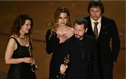  ?? Patrick T. Fallon/AFP via Getty Images ?? Ukrainian filmmaker Mstyslav Chernov, flanked by Raney Aronson-Rath, Vasilisa Stepanenko and Evgeniy Maloletka, accepts the award for Best Documentar­y Feature Film for “20 Days in Mariupol” during the Academy Awards.