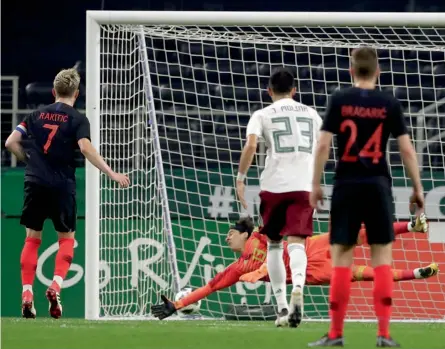  ?? — AP ?? Croatia’s Ivan Rakitic ( left) scores past Mexico goalkeeper Guillermo Ochoa in their internatio­nal friendly at the AT& T Stadium in Arlington, Texas, on Wednesday. Croatia won 1- 0.