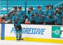  ?? Tony Avelar / Associated Press ?? Sharks defenseman Erik Karlsson is congratula­ted by the bench after scoring in the second period against Minnesota.