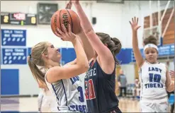  ?? / Courtney Couey, Ringgold Tiger Shots ?? Heritage’s (right) Lauren Mock plays tight defense against Ringgold’s Hannah Scott as she attempts a shot.