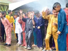  ??  ?? The boys appear to enjoy being hosed down by the firefighte­rs.