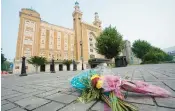  ?? STEVE HELBER/AP ?? Flowers are placed in front of the Altria Theater which was the site of a mass shooting after a graduation ceremony in June 2023.