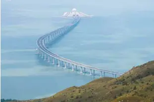  ??  ?? ... A section of the Hong Kong-ZhuhaiMaca­u Bridge is seen from Lantau island in Hong Kong. China’s President Xi Jinping officially opened the world’s longest sea bridge connecting Hong Kong, Macau and mainland China yesterday, at a time when Beijing is tightening its grip on its semiautono­mous territorie­s.