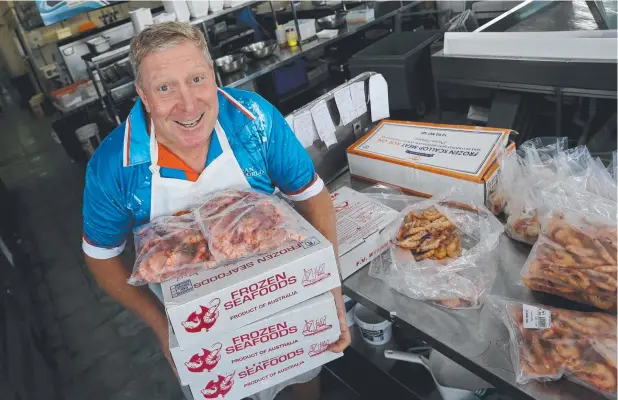  ?? Picture: STEWART McLEAN ?? CHRISTMAS RUSH: Ocean World Seafood Market owner Peter Adams with boxes of prawns as they stock up for an expected surge in demand.