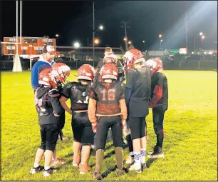  ??  ?? The Portage Pop Warner Pee Wee football team huddles during a cold evening practice at Willowcree­k Middle School in Portage.