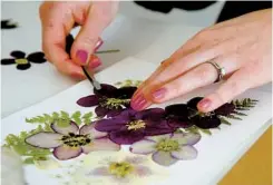  ?? JOHN GIBBINS U-T PHOTOS ?? Liz Wagner, creative director for The Crafter’s Box, videograph­er Dustin Bailey and dried plant artist Karly Murphy talked while making a video Thursday about how to press flowers and use them to create art.