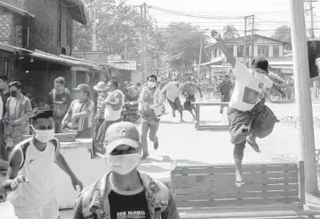  ?? GETTY/AFP ?? Protesters run from police Friday during a crackdown on demonstrat­ions against the military coup in Naypyidaw, Myanmar. Also on Friday, Myanmar’s U.N. ambassador, Kyaw Moe Tun, strongly appealed for the “strongest possible action from the internatio­nal community” to immediatel­y restore democracy during a speech to the U.N. General Assembly.