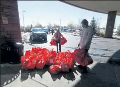  ??  ?? Volunteers with the Christian nonprofit Serve 6.8 Transformi­ng Community unload bags of toys and school supplies at the entrance to the Embassy Suites Hotel in Loveland on Wednesday,