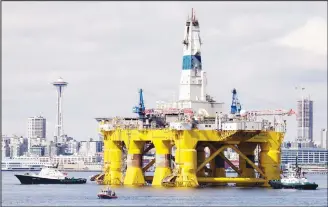  ?? (AP) ?? In this file photo, the oil drilling rig Polar Pioneer is towed toward a dock in Elliott Bay in Seattle. The government says US oil production will keep climbing and set new records in 2019 and 2020 while oil prices willremain below last year’s levels.
