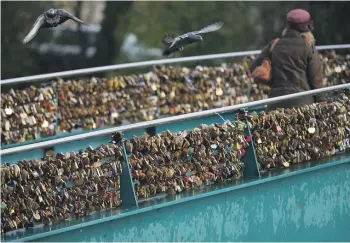  ?? GETTY IMAGES ?? Thousands of padlocks known as “love locks” adorn a bridge across the River Wye in Bakewell, England. Tourism chiefs worldwide are pushing back against the practice, saying it is a form of vandalism and littering.