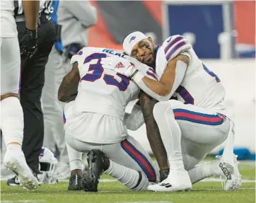  ?? JEFF DEAN/AP ?? The Buffalo Bills’ Siran Neal, cener, and Nyheim Hines react after teammate Damar Hamlin was injured during the first half of an game against the Cincinnati Bengals in Cincinnati on Jan. 2.