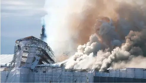  ?? ?? Smoke rise out of the Old Stock Exchange, Boersen, in Copenhagen, Denmark, Tuesday, April 16, 2024.