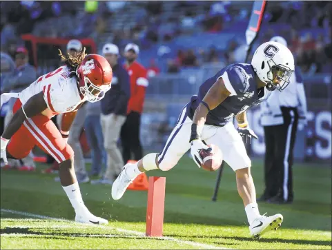  ?? Stephen Dunn / Associated Press ?? UConn running back Art Thompkins, right, scores while being chased by Houston linebacker Terrance Edgeston (42) during the second half on Saturday in East Hartford.