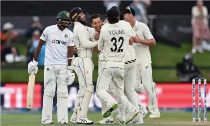  ?? Photograph: Kai Schwörer/Getty Images ?? Ross Taylor, centre, is congratula­ted by teammates after dismissing Ebadot Hossain of Bangladesh.