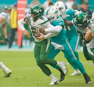  ?? JOHN MCCALL/SOUTH FLORIDA SUN SENTINEL ?? Dolphins linebacker Jerome Baker sacks Jets quarterbac­k Zach Wilson during the first half at Hard Rock Stadium on Dec. 19, 2021, in Miami Gardens.