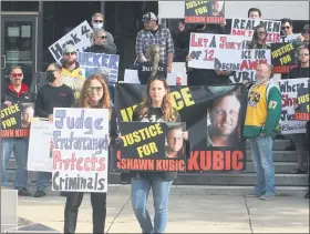  ?? DAVID ANGELL — FOR THEMACOMB DAILY ?? Kathleen Zelmanski and Kelly Ingels, the mother and sister respective­ly of Shawn Kubic, stand in front of about two dozen supporters on the front steps of the Macomb County Circuit Courthouse Tuesday afternoon. They were protesting the suspect being charged with a lesser offense.