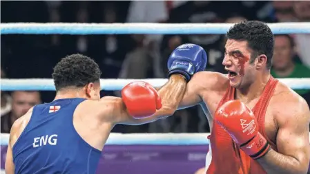  ?? PTI ?? Bruised and bloodied: Sagar Ahlawat fights England’s Delicious Orie during the men’s super heavyweigh­t final. Ahlawat was the surprise package of the event, landing a silver on his Games debut.