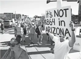  ?? MICHAEL CHOW/ARIZONA REPUBLIC ?? Demonstrat­ors hold signs against the 1864 near-total territoria­l abortion ban on Sunday while protesting in Scottsdale, Ariz.