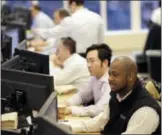  ?? THE ASSOCIATED PRESS ?? Traders work on the Mizuho Americas trading floor in New York. Wall Street notched another set of milestones Monday as the Dow Jones industrial average closed at a record high for the 12th consecutiv­e time.
