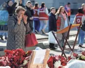  ?? MAXIM SHEMETOV/REUTERS ?? People visit a makeshift memorial near the Crocus City Hall near Moscow on Wednesday. It was the site of Friday’s deadly attack.