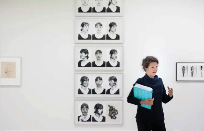  ?? KRISTIAN JACOBSEN ?? Kurator Hanne Beate Ueland står foran et av mange verk der kvinner på 70-tallet tok i bruk sitt naermeste og sterkeste våpen – seg selv. I Stavanger Kunstmuseu­m kan du se hvordan kvinnene skrev om regelboka for 40–50 år siden.