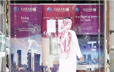  ??  ?? A man stands outside the Qatar Airways branch in Riyadh on Monday after the carrier suspended all flights to Saudi Arabia following a severing of relations between major Gulf states and Doha. (AFP)