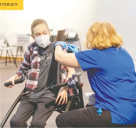  ?? BILL BRADEN / THE CANADIAN PRESS ?? Sixteen-year-old Riley Oldford, who has cerebral palsy, became the first young person in the Northwest Territorie­s to get the Pfizer vaccine when he was inoculated by nurse practition­er Janie Neudorf in Yellowknif­e on Thursday. Those as young as 12 have been approved for the Pfizer shots.