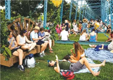  ?? STAFF PHOTOS BY DOUG STRICKLAND ?? Fans shelter beneath the Walnut Street Bridge Saturday after inclement weather delayed some shows on the first day of the Moon River music festival at Coolidge Park. The Head and the Heart headlined Saturday night’s festival, which continues today.