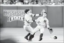  ??  ?? ASSOCIATED PRESS Mississipp­i State second baseman John Holland (left) and center fielder Jacob Robson fail to catch a shallow pop fly in the ninth inning on Saturday.