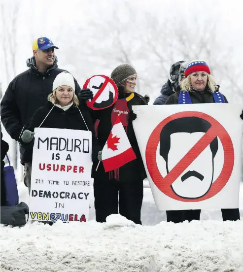  ?? DAVID KAWAI / BLOOMBERG ?? Anti-Maduro demonstrat­ors hold signs outside a meeting of the Lima Group in Ottawa on Monday. Pro-democracy activists are criticizin­g two major Canadian unions for their support of the embattled Venezuelan leader.