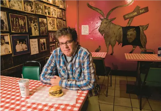  ?? ZBIGNIEW BZDAK/CHICAGO TRIBUNE ?? George Motz, sitting with a triple cheeseburg­er at the Billy Goat Tavern in Chicago in 2013, is America’s leading hamburger expert.