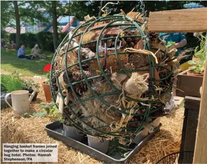  ?? ?? Hanging basket frames joined together to make a circular bug hotel. Photos: Hannah Stephenson/PA