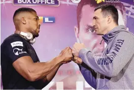  ?? MATT DUNHAM/ASSOCIATED PRESS ?? Anthony Joshua, left, and Wladimir Klitschko pose while promoting their heavyweigh­t title bout. They meet Saturday night in England where 90,000 fans are expected to be in attendance.