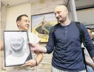  ?? PHOTO: REUTERS ?? Resurrecte­d . . . Russian dissident journalist Arkady Babchenko (right) takes his portrait from deputy chief of the Crimean Tatar channel ATR Aider Muzhdabaie­v as he visits the channel’s office in Kiev, Ukraine, after it was revealed the reports of his assassinat­ion last week were not true.