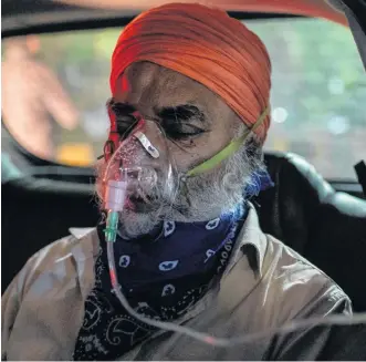  ?? REUTERS ?? A man with a breathing problem receives oxygen support for free inside his car at a Gurudwara (Sikh temple) in Ghaziabad, India, on Saturday. On Monday, India reported 352,991 new infections and 2,812 deaths in the last 24 hours, bringing its case total to more than 17 million.