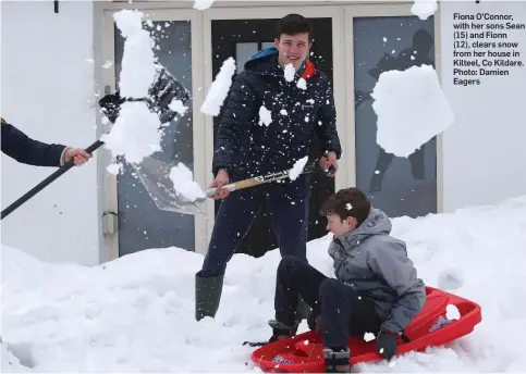  ?? Photo: Damien Eagers ?? Fiona O’Connor, with her sons Sean (15) and Fionn (12), clears snow from her house in Kilteel, Co Kildare.