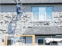  ?? POSTMEDIA ?? Mohammad Roshid from TR Exteriors Ltd. inspects a hail-damaged home in Saddle Ridge, Alta., on June 25.