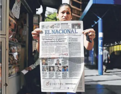  ??  ?? ► Una mujer muestra la última edición impresa del periódico venezolano El Nacional con su portada que dice “El Nacional es un guerrero y seguirá dando la batalla”, ayer en Caracas.