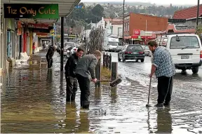  ??  ?? Cleaning up after groundwate­r flooding in South Dunedin.