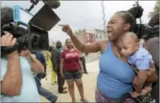  ??  ?? Massieka Holness, of Baltimore, with her four-month-old son, Tavon, reacts after prosecutor­s dropped all charges against police in Baltimore, Wednesday. Prosecutor­s on Wednesday dropped all remaining charges against the three Baltimore police officers...