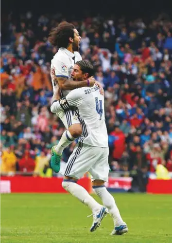  ?? AFP ?? Real Madrid’s Marcelo celebrates after scoring the last goal with teammate Sergio Ramos in a La Liga match against Valencia at the Santiago Bernabeu Stadium, Madrid yesterday.