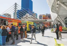  ?? Gabrielle Lurie / The Chronicle ?? Patrons line up at the food trucks near the Transbay terminal in San Francisco in March. Restaurant­s are seeking to ease the permit process for food trucks.