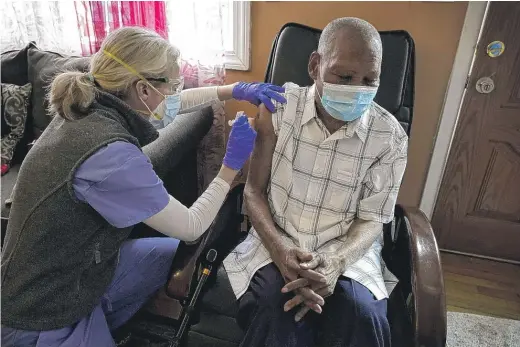  ?? STEVEN SENNE/AP ?? Geriatrici­an Dr. Megan Young gives Edouard Joseph, 91, a COVID-19 vaccinatio­n at his home in Boston’s Mattapan neighborho­od. Millions of U.S. residents will need COVID-19 vaccines brought to them because they rarely or never leave home.